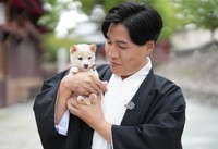 吉開宮司とチビシロ。子犬の可愛さに宮司もメロメロ