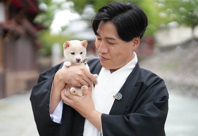 吉開宮司とチビシロ。子犬の可愛さに宮司もメロメロ