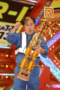 「R-1ぐらんぷり」の優勝トロフィーを手にガッツポーズを決める三浦マイルド＝2013年2月12日