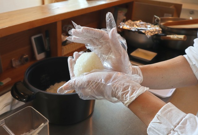 炊きあがったごはんを1個ずつ手作業で握る