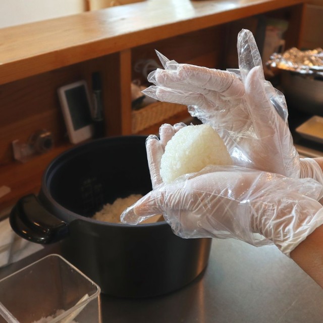 炊きあがったごはんを1個ずつ手作業で握る