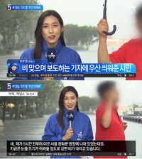 横から傘を差す男性が突然現れ、記者も少し笑みがこぼれている（出典：チャンネルA YouTube動画キャプチャー）