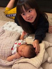 新生児の頃の次女ちゃんを優しくなでる長女ちゃん（提供：＠iamasawaさん）

