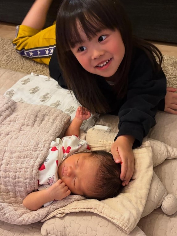 新生児の頃の次女ちゃんを優しくなでる長女ちゃん（提供：＠iamasawaさん）
