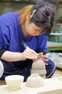 碗の底部を削り出す作業に打ち込む訓練生
