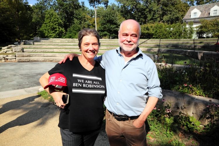ベン・ロビンソン准教授（右）と同僚のマリア・ブクル教授。ブクル教授の着るTシャツには「WE ARE ALL BEN ROBINSON」（私たちはみなベン・ロビンソンだ）とある=2025年9月、米国・ブルーミントン、秋山訓子撮影