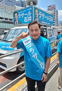 参院選での第一声後、炎天下の選挙カー前でポーズを取るラサール石井＝東京・ＪＲ新宿駅南口