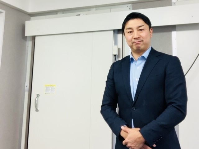 自社で手がけた防熱扉の前に立つ岸産業3代目の岸晃広さん（写真はすべて岸産業提供）