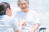 手を合わせる高齢者の女性と介護士※画像はイメージです（buritora/stock.adobe.com）