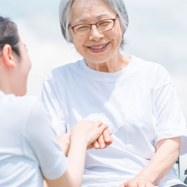 手を合わせる高齢者の女性と介護士※画像はイメージです（buritora/stock.adobe.com）