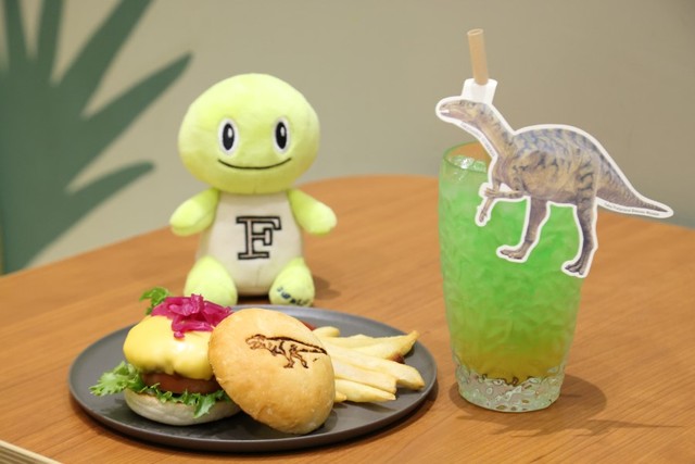 粗挽きの牛肉100%で、肉の旨みをしっかりと感じられる「肉食ティラノバーガー」1500円。福井の恐竜をイメージしたノンアルコールの「カクテルソーダ」600円。「サウタンはフクイサウルスのカクテル推しじゅら」