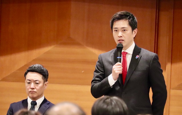 大阪維新の会全体会議の冒頭であいさつする吉村洋文氏（左は横山英幸氏）＝大阪市内