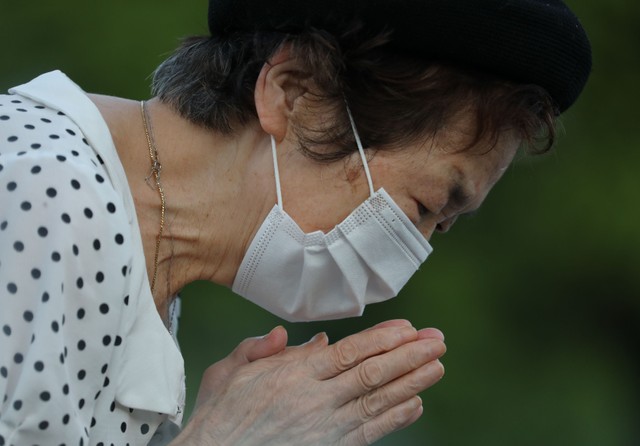 原爆死没者慰霊碑前で手を合わせる女性＝2021年8月6日午前5時49分、広島市中区、上田潤撮影