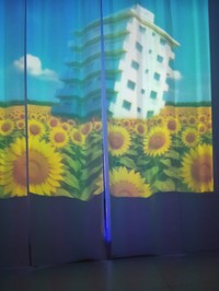 会場には終末後の世界を表現したシアター空間も。ヒマワリ畑の中で傾いたビル（「1999展－存在しないあの日の記憶－」より）