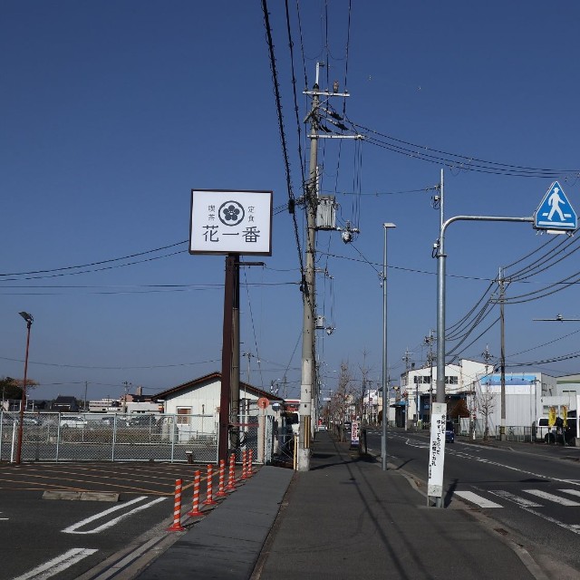 何の変哲もない郊外の町　「花一番」の看板横に立つ電柱のてっぺんにフクロウが？