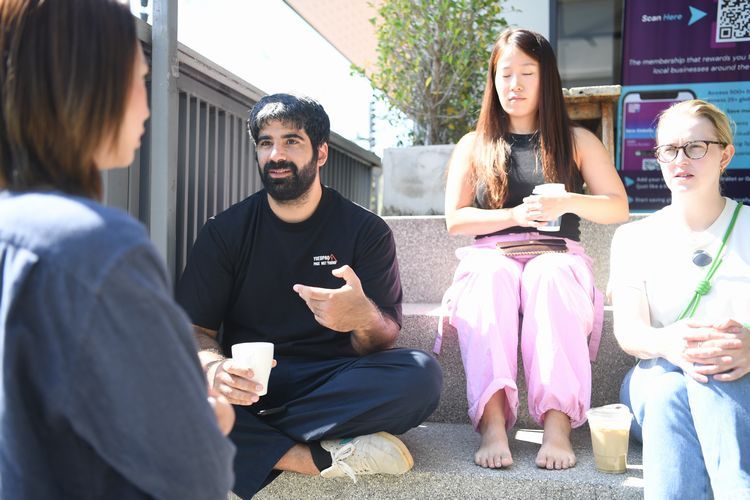 仕事の合間にコワーキングスペースの外で友人と談笑していたトルコ出身のカーンさん（右から3人目）