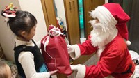 ブックサンタ事業で集まった本をクリスマスに子どもへ届けるボランティアのサンタクロース（ＮＰＯ法人チャリティーサンタ提供）
