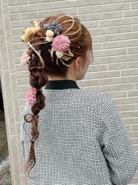 姉が手がけた妹の成人式のヘアセット。ドライフラワーや水引で華やかに飾られている／uniさん（@momoel2023）提供