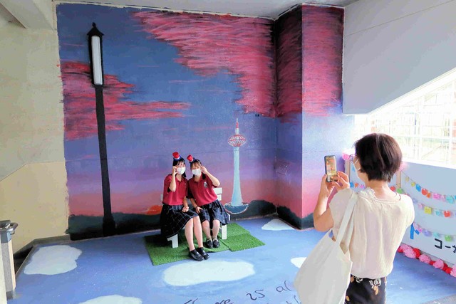 壁画の前で写真を撮る生徒たち。「自分たちでかわいく校舎を装飾できてうれしい」との声も聞かれた