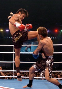 魔裟斗（左）が跳びひざ蹴りを山本“ＫＩＤ”徳郁の顔面に放つ