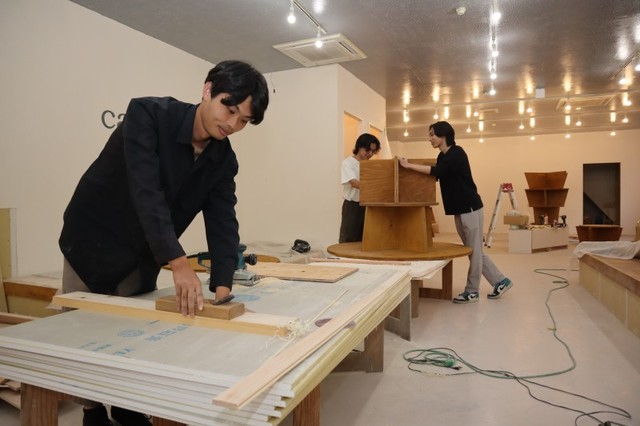 オープンに向けて内装工事に汗を流す森岡さん（手前）ら
