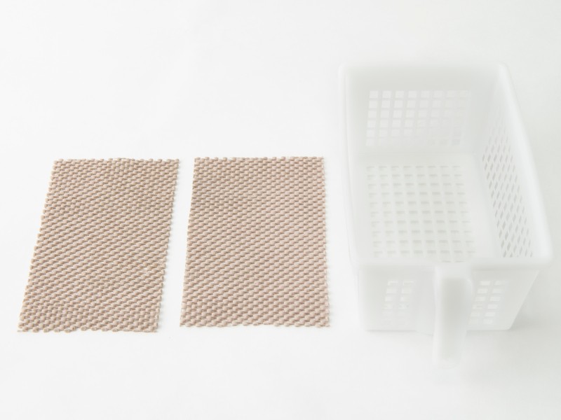 滑り止めシートをプラスチックケースの底に合わせて２枚カット（扶桑社提供）