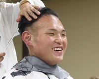 笑顔で髪を整える湊川親方＝2025年10月撮影