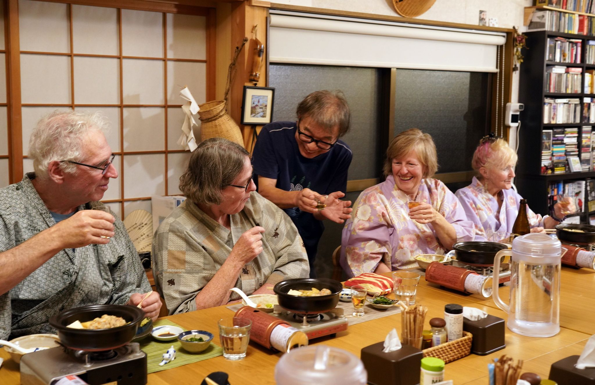 夕食時に宿泊客と乾杯する天野泰行さん（真ん中）＝和歌山県田辺市、外山俊樹撮影