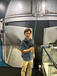 オビワンのライトセーバー（緑）を手にする、なべやかん。アクション撮影で使われる簡易な作りの「アクション用」だ＝幕張メッセ