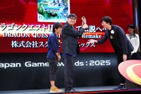 年間優秀賞のトロフィーを受け取り、笑顔で掲げる堀井雄二氏