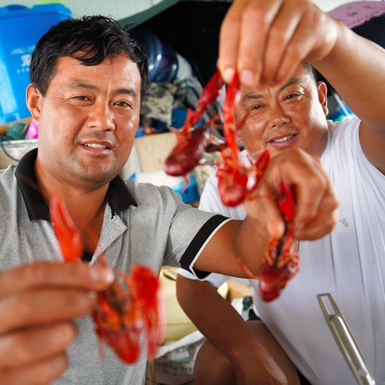 ザリガニの養殖を営む蘆立軍さん（左）