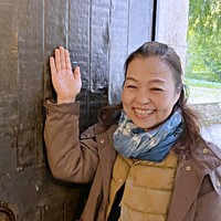 30年越しの夢を実現。「YASUKO」の文字が刻まれた門扉の前で笑みを浮かべるタカハシさん（画像提供：タカハシ ヤスコさん）