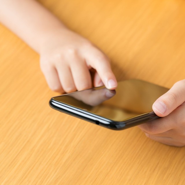 スマートフォンを操作する子どもの手元 ※画像はイメージです（Hanasaki/stock.adobe.com）
