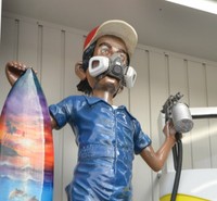 人形はマスクやスプレー缶など作業員が実際に使用する道具を身に着けている。サーフボードは謎だが…