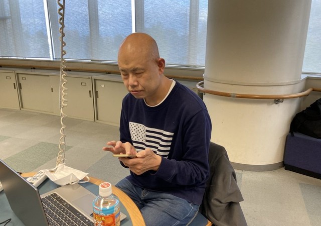 スマートフォンを操作する小川さん