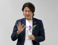 ワイングラスに花を生けて「いけばなは生活文化でもある」と説明する藤井さん