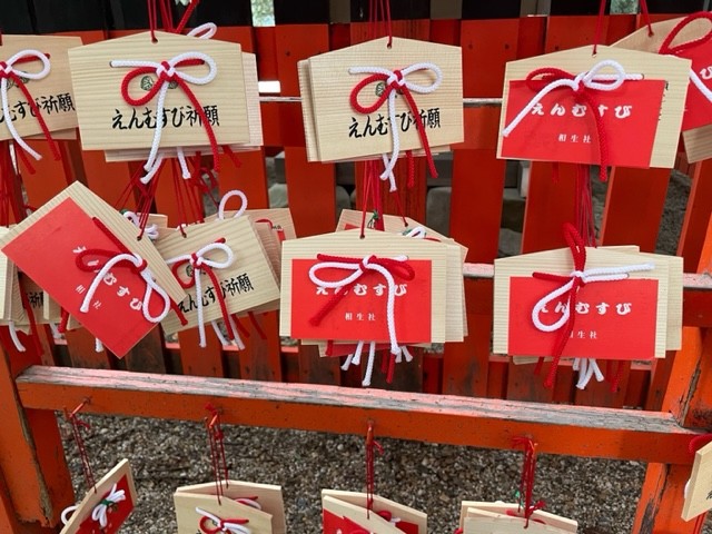 下鴨神社の絵馬。赤と白のリボンが印象的な五角形に、真っ赤なシールが映える（下鴨神社提供）