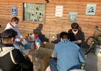 子どもたちに無料配布する食料を仕分けするNPO法人「グッド・ファミリー」のスタッフら