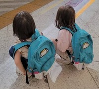 新幹線のリュックを背負い、はやぶさを見つめる子どもたち。家族で東京駅へ見学に訪れたという／MOEさん（@hoppe.mochimochi）提供※画像はトリミングしています