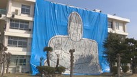 ブルーシートに新聞紙を貼って描かれた大仏