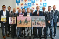 京丹後市に寄贈された故谷垣夫妻のアルバムや絵画などを囲む関係者ら（同市役所）