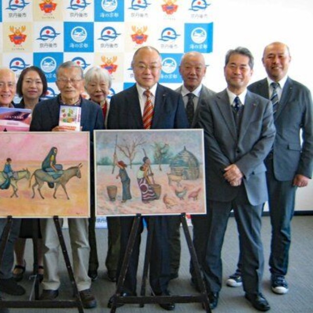 京丹後市に寄贈された故谷垣夫妻のアルバムや絵画などを囲む関係者ら（同市役所）