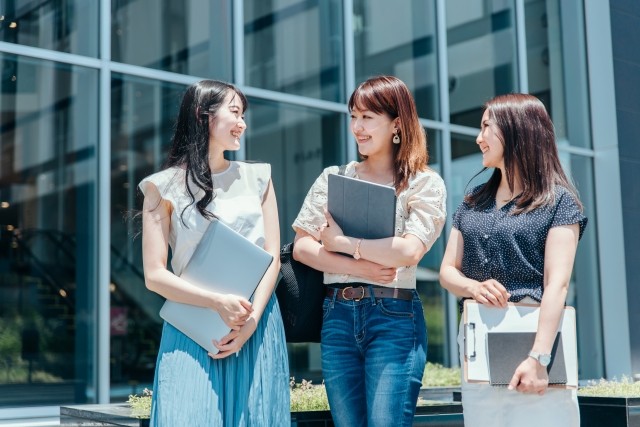 タブレットを持ち歩く女性たちの画像