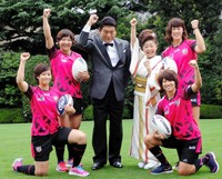女子ラグビー選手たちとトライを決めガッツポーズを決める増位山太志郎（左）と中村美律子＝2014年