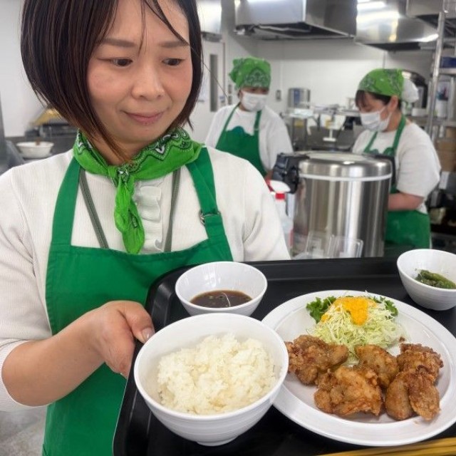一番人気の唐揚げがメインの定食。岩崎さん（左端）らが食堂を切り盛りする＝９月１６日、倉敷市平田