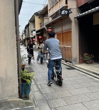 レンタルバイクにまたがり、道を塞いで撮影する訪日外国人観光客（画像：筆者撮影）