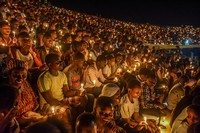 ルワンダの首都キガリの国立競技場で開かれた追悼式典でろうそくに火をともし、虐殺の悲劇を記憶することを誓う参加者