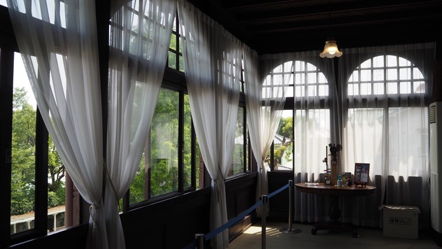 ２階南東向きのベランダ。100年前の、少し凹凸のある窓ガラスから入る陽光が柔らかい。窓上部の半円形は、アール・ヌーヴォーの特徴のひとつ