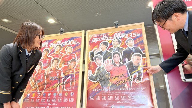 ＪＲ岡山駅構内に張り出されたオマージュポスターの注目ポイントを指さす「ファジアーノ盛り上げ隊」メンバー
