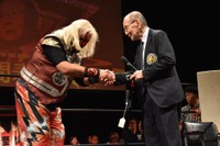 昨年12月、怪獣プロレスのリングに上り、コミッショナーに就任した新間寿さん（右）と団体代表の雷神矢口＝東京・町田市民ホール